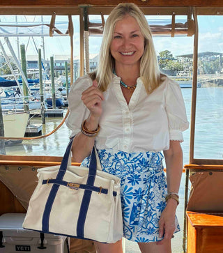 Woman holidng a natural and navy boatkin bag