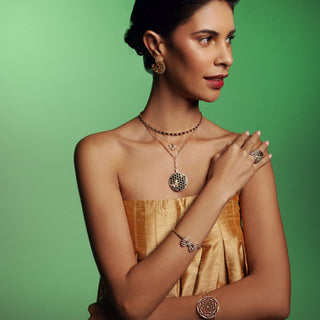 Woman wearing Queen Bee Artemis gold and diamond necklace.