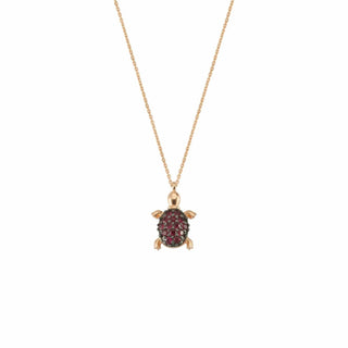 Gold turtle necklace with ruby gemstone.