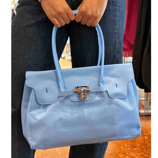 Blue jelly firkin bag with glossy finish, top handles, and front lock detail