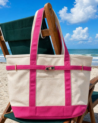 Hot pink zip top boatkin tote hanging on a beach chair