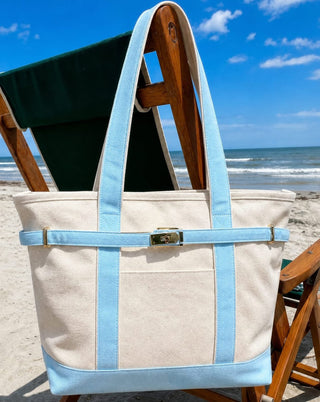 boatkin zipper tote in blue hanging on beach chair