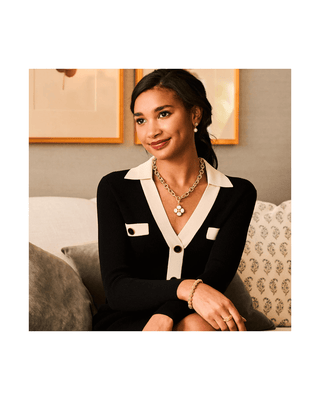 Woman in black cardigan with gold necklace