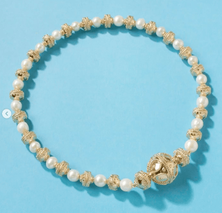 Necklace with pearls and gold beads on a blue background