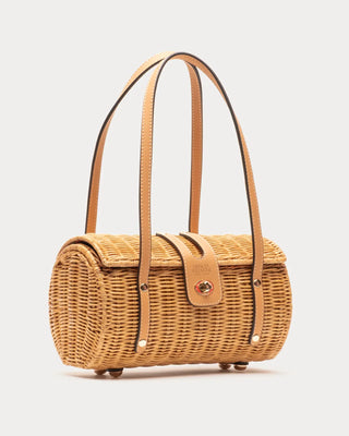 Wicker barrel shape handbag by Frances Valentine with leather straps on a light gray background