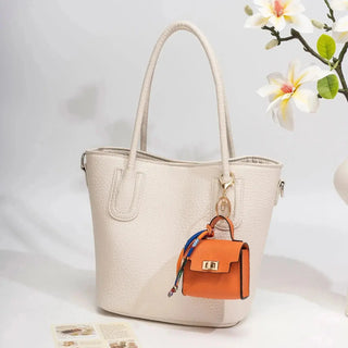 Mini handbag bag charm keychain shown clipped to a handbag