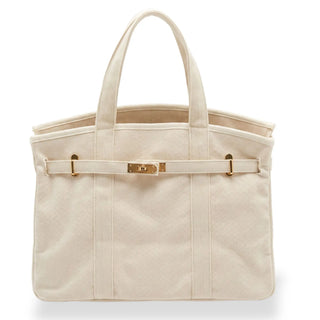 An off-white canvas boatkin tote bag with a matching front strap and gold-tone hardware, shown against a plain white background.