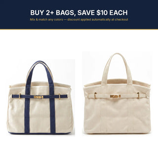 Two canvas tote bags shown side by side on a white background, with a dark navy promotional banner at the top reading 'BUY 2+ BAGS, SAVE $10 EACH'. The left bag has navy blue handles and vertical straps with gold-tone hardware, and the right bag is the same colorway with gold-tone hardware only visible.