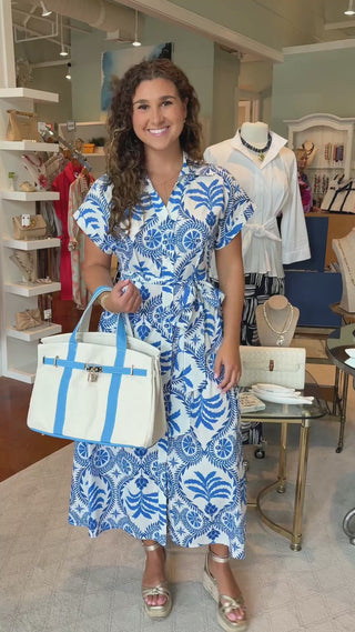 a video of a young woman holding a carolina blue color boatkin bag
