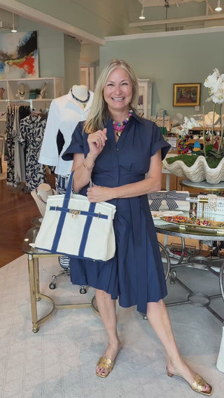 a video of a woman carrying a navy blue boatkin bag