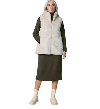 A model wearing a light beige faux-fur puffer vest over a dark olive green long-sleeve top and matching midi skirt, paired with cream ankle boots, on a solid white background.
